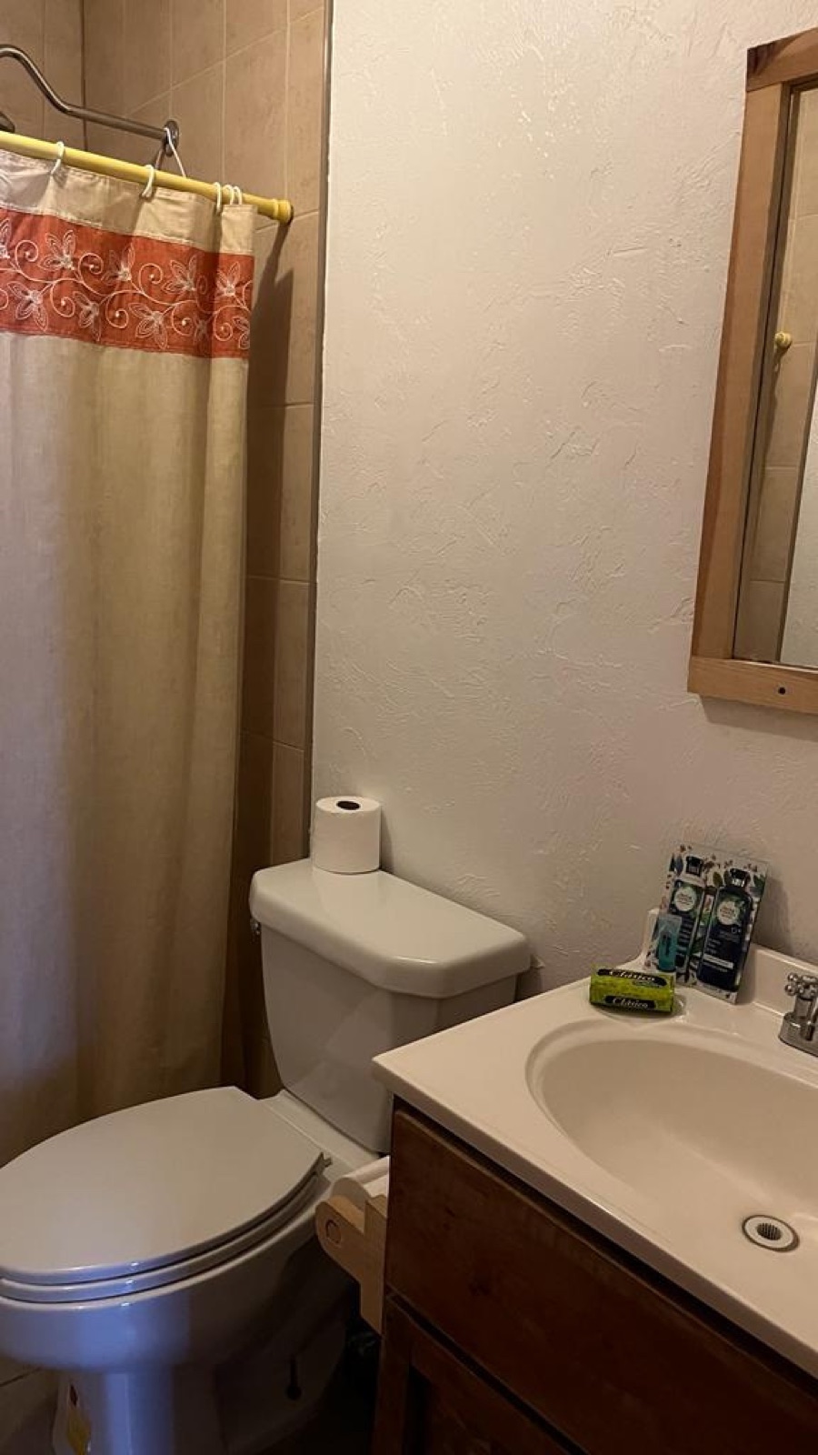 Lodge bathroom — clean tile and floral shower curtain