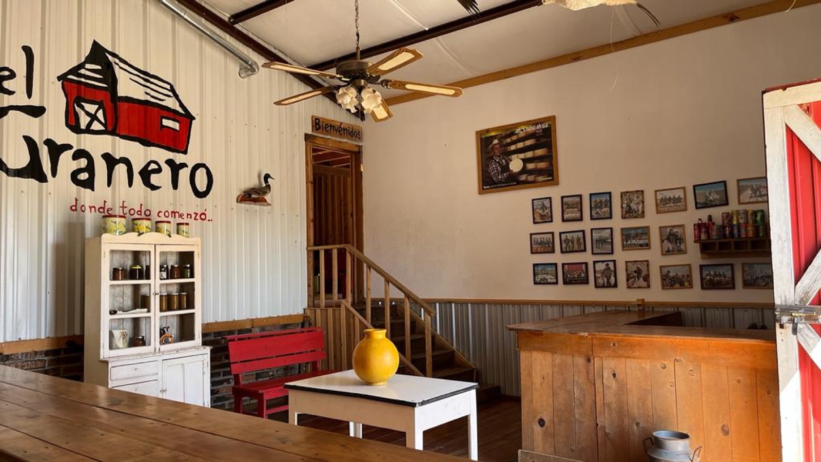 El Granero dining hall — wood walls, "donde todo comenzó" mural, framed history